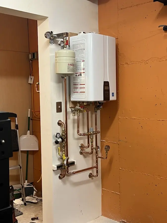 Plumbing technician inspecting water heater connections in Rossford